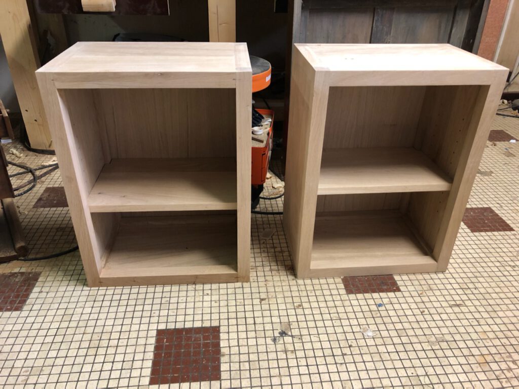 Deux meubles en bois brut avec étagères, en cours de finition par un ébéniste à Deauville.