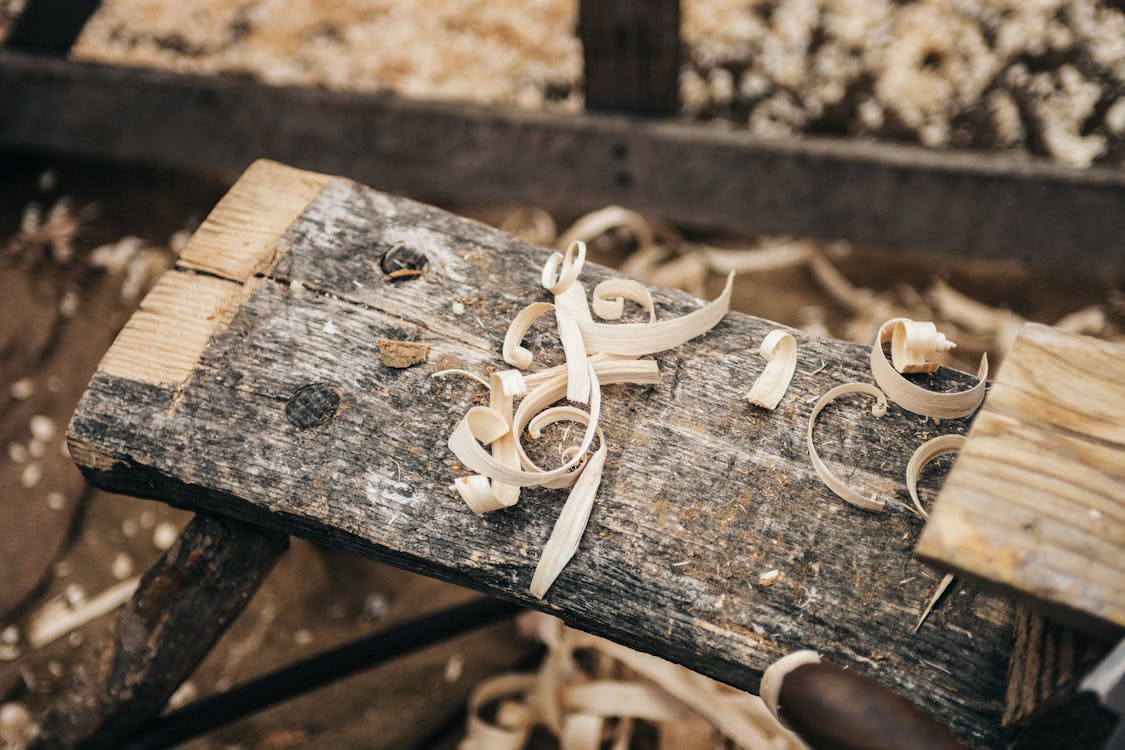 Échardes de bois sur un établi, témoignant du travail d'ébénisterie et de restauration artisanale.