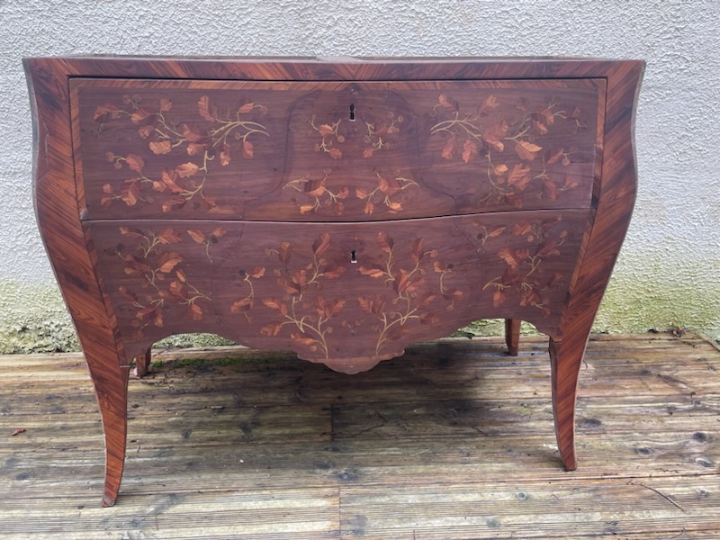 Commode Louis XV signée Dubois, ornée de motifs floraux, en bois précieux avec des pieds délicatement courbés.